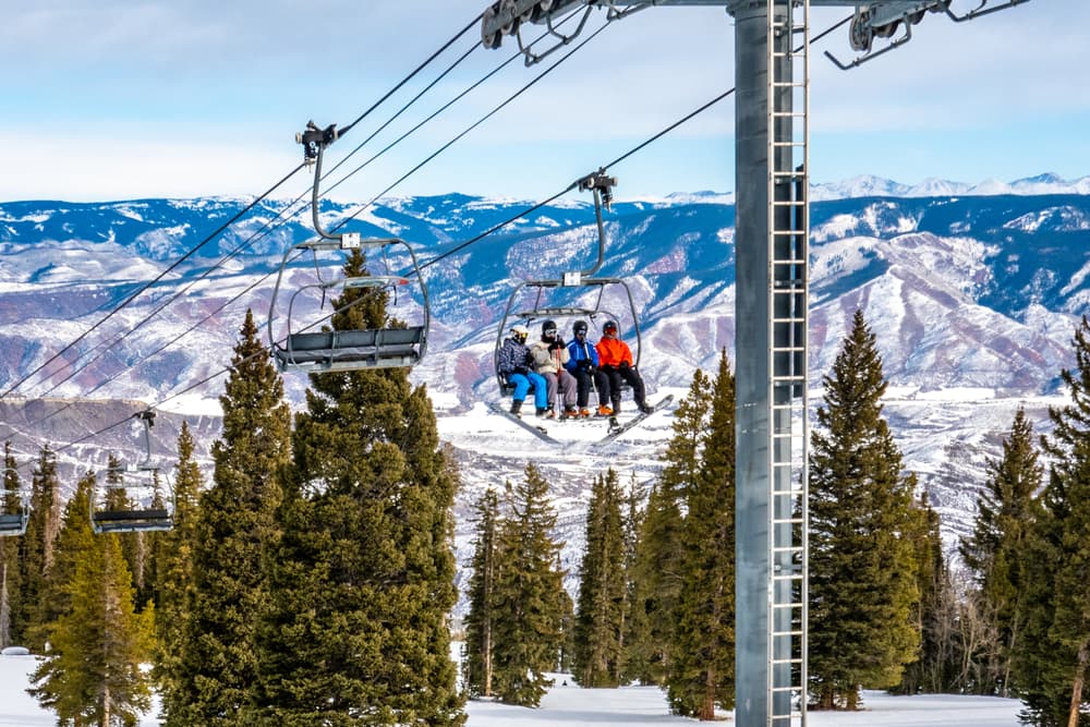 skiers on ski lift in colorado