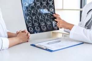 A professor and doctor is having a conversation with a patient while holding an X-ray film, discussing and explaining symptoms, or providing a diagnosis and health counsel.