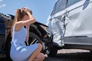 A young woman suffering from a head injury after a serious rear-end collision on the road. 