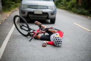 An Asian mountain biker was injured in a collision with a car on the road. 
