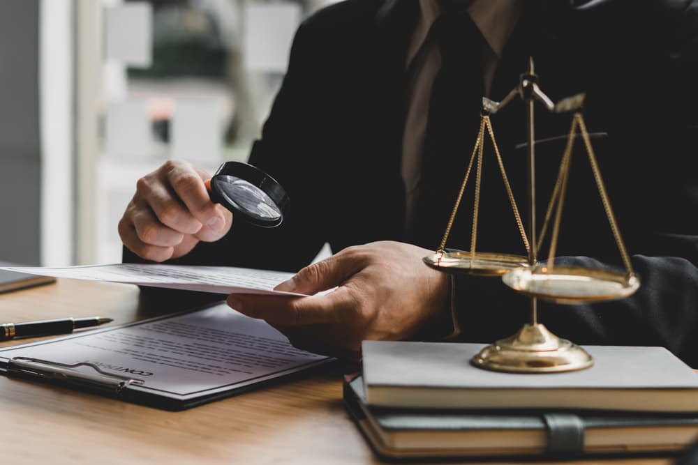 Personal injury lawyer closely examining documents with a magnifying glass to evaluate critical evidence for an accident claim.