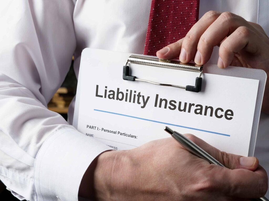 Business professional holding a clipboard with a liability insurance form and signing paperwork.